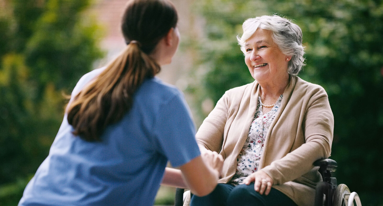 a senior woman in a wheelchair being cared for a nurse