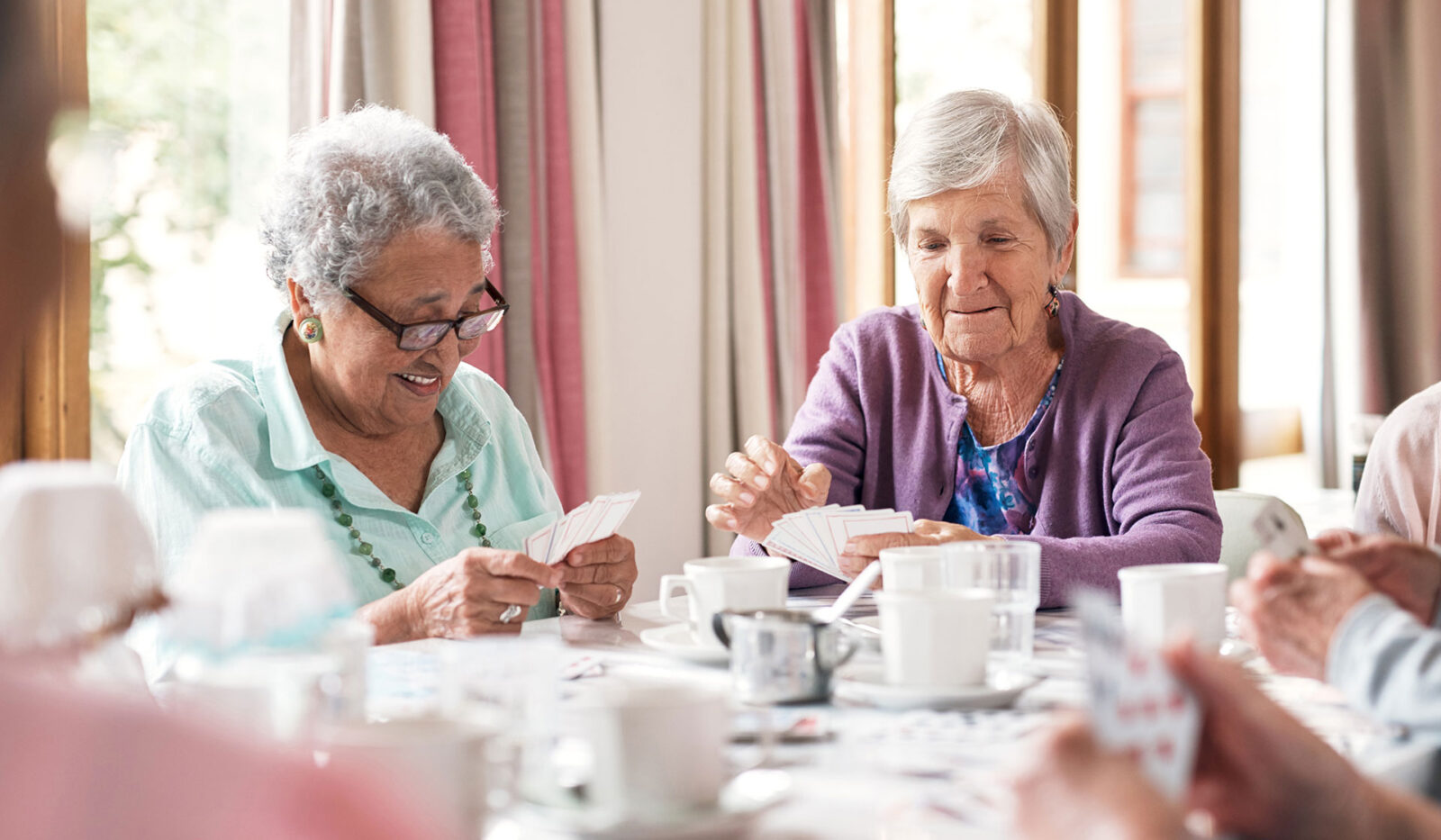 a group of senior women playing cards together at a retirement home